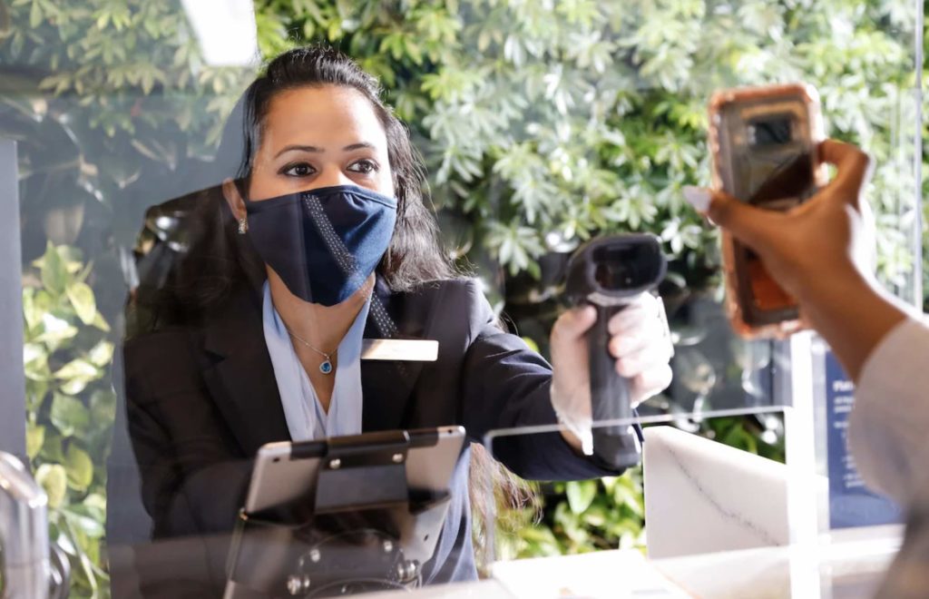 a woman wearing a face mask and holding a device