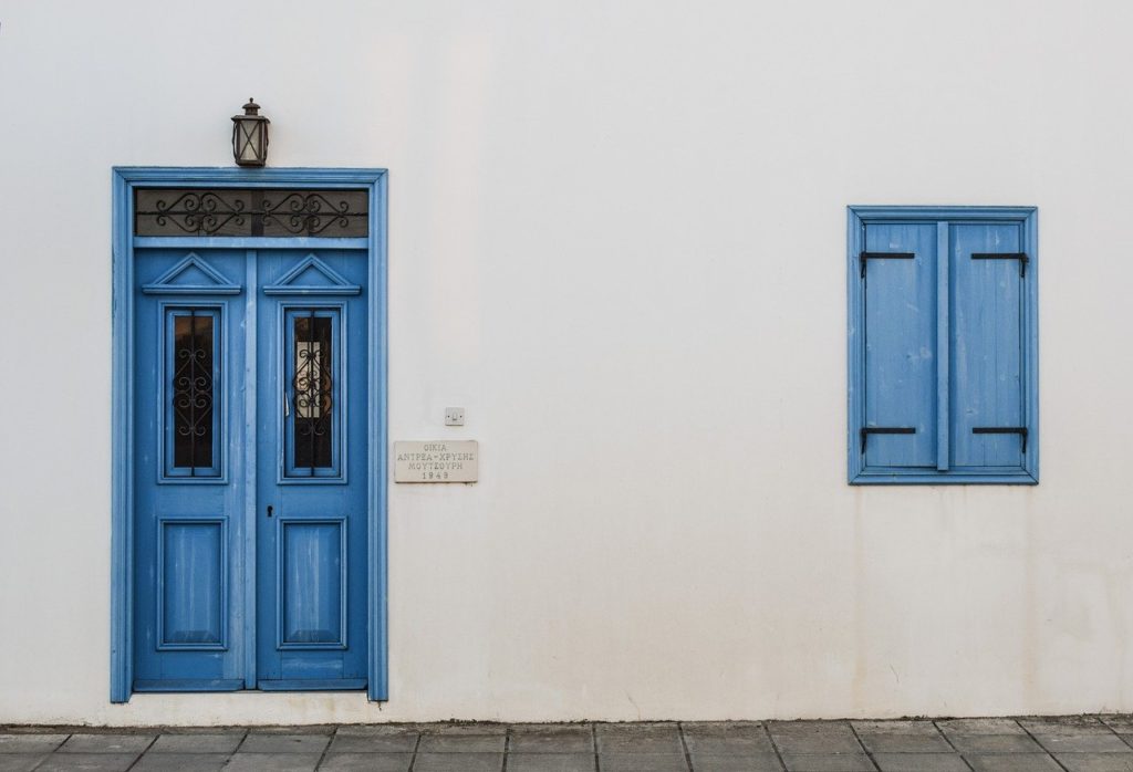 a blue door and window on a white wall