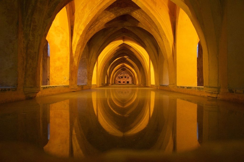 a yellow hallway with arched ceiling and water