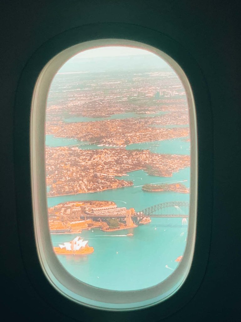 an airplane window with a city and water