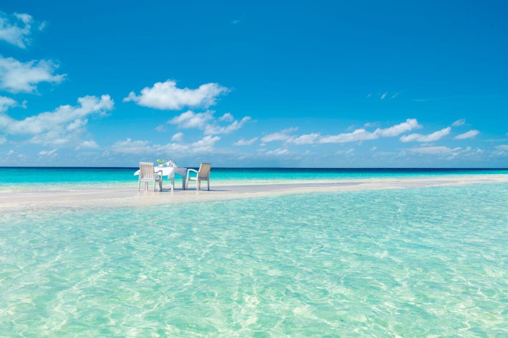 a table and chairs on a beach