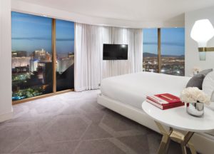 a bedroom with a large window and a city view