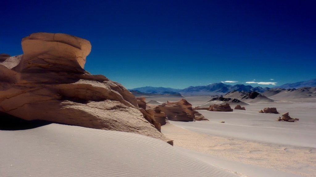 a desert landscape with sand and mountains