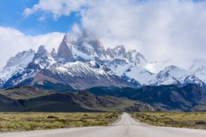 a road leading to snowy mountains with Fitz Roy in the background