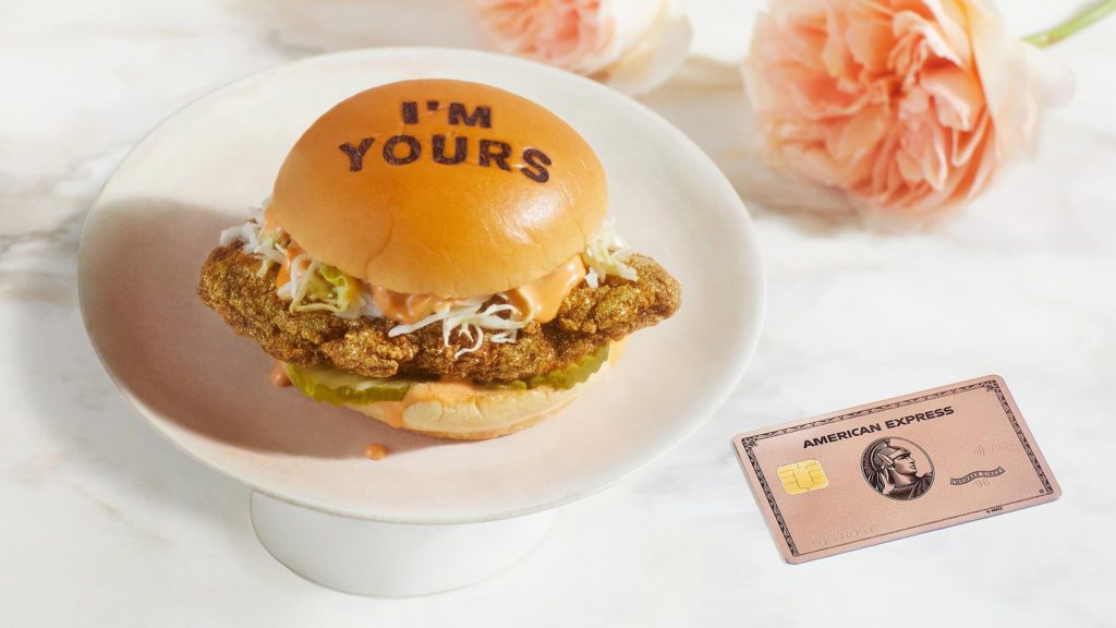 a burger on a plate next to a credit card