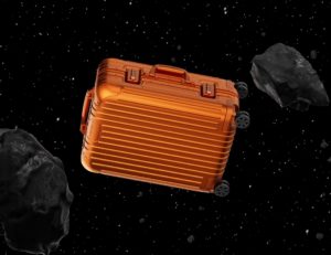 a suitcase in space with black rocks