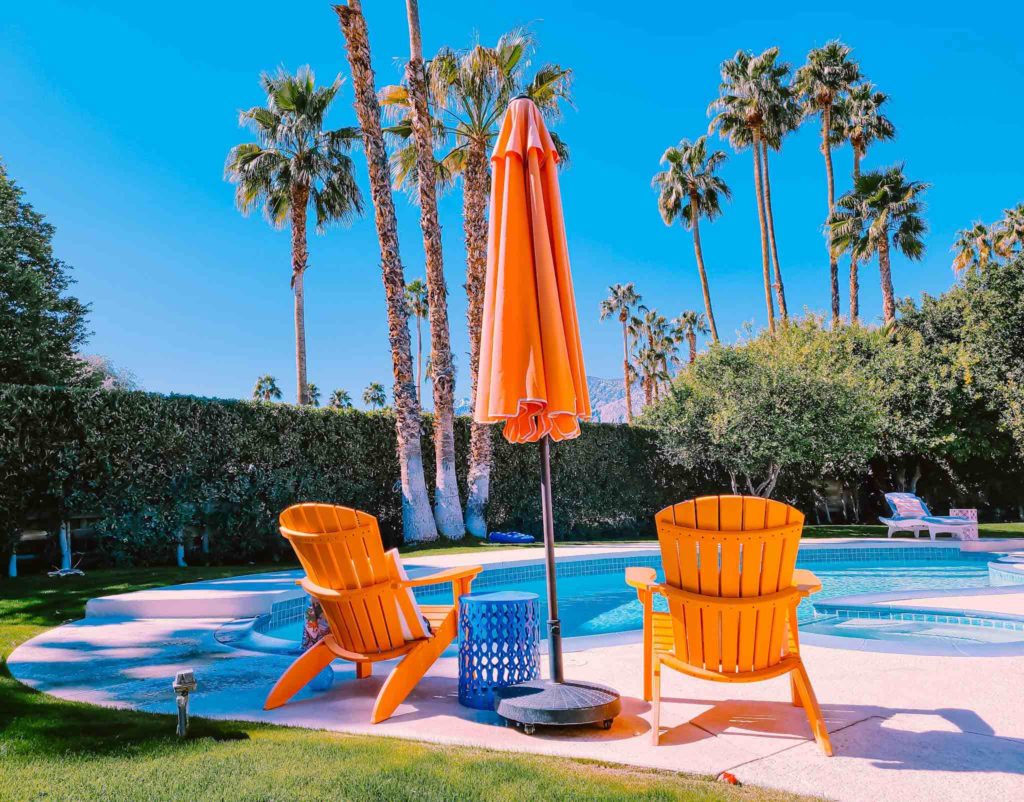 a pool with palm trees and chairs