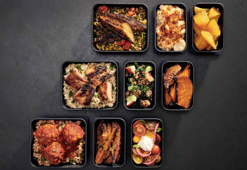 a group of black containers with food in them
