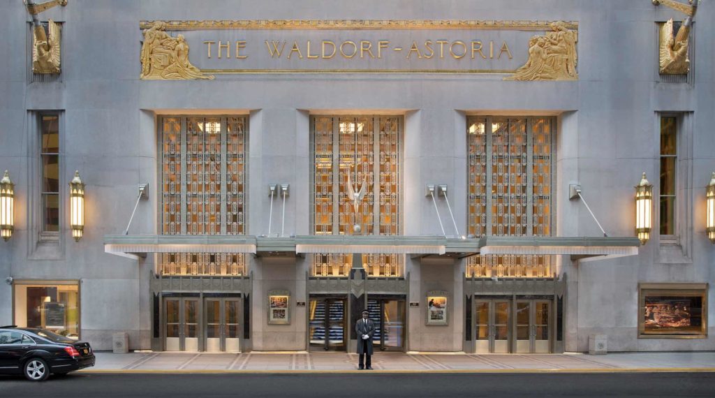 a man standing in front of Waldorf Astoria New York