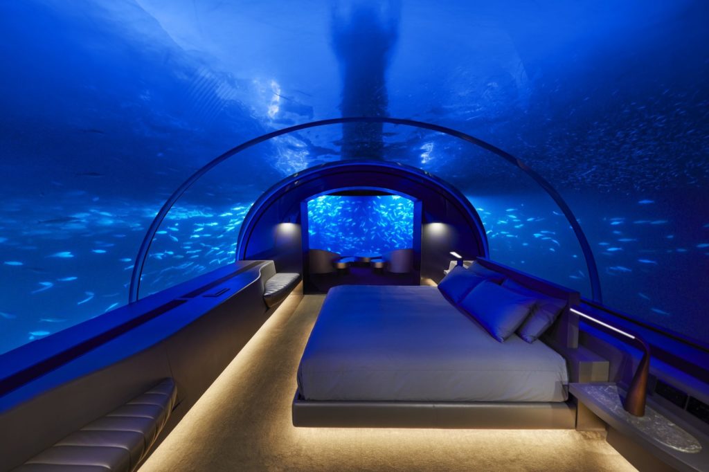 a bed inside a room with fish tank