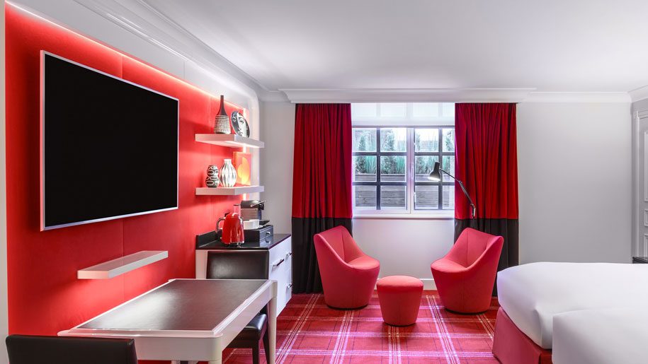 a room with red curtains and a tv