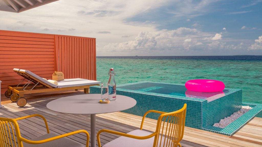 a table and chairs next to a pool