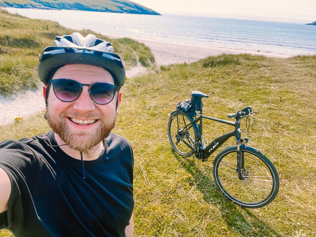 a man taking a selfie with a bicycle in the background