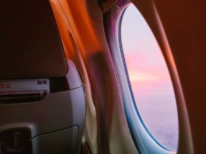 an airplane window with a pink sky