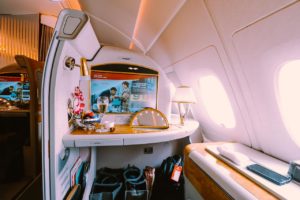 a table with a tv and a glass of champagne in the back of an airplane