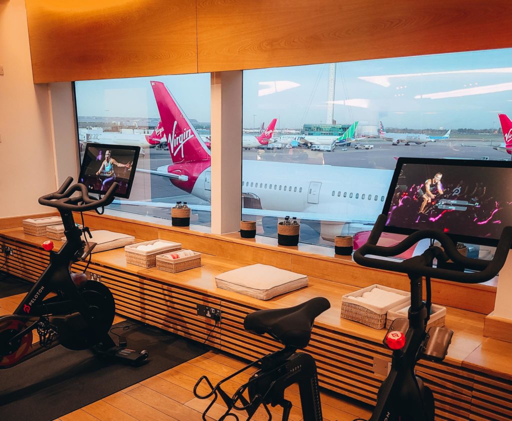 a room with exercise bikes and a window with airplanes in the background