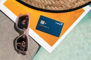 a credit card and sunglasses on a stone