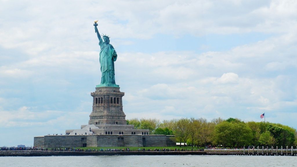 a statue of liberty with a body of water and trees