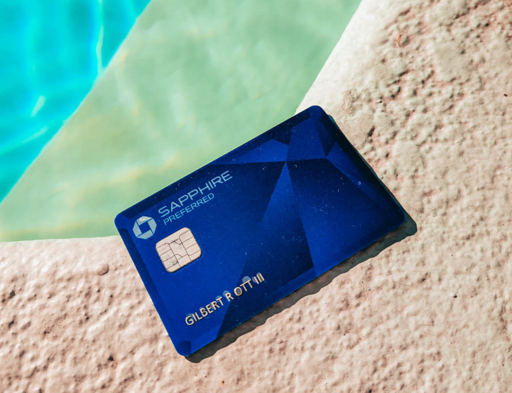 a blue credit card on a ledge by a pool