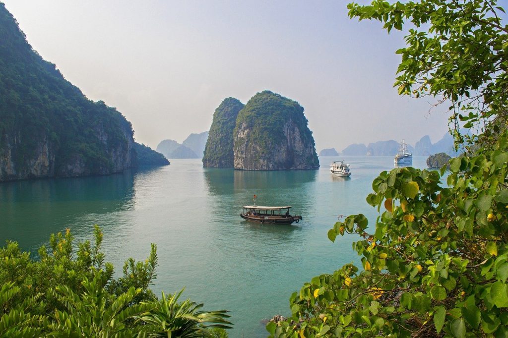 boats in the water with a boat in it with Ha Long Bay in the background