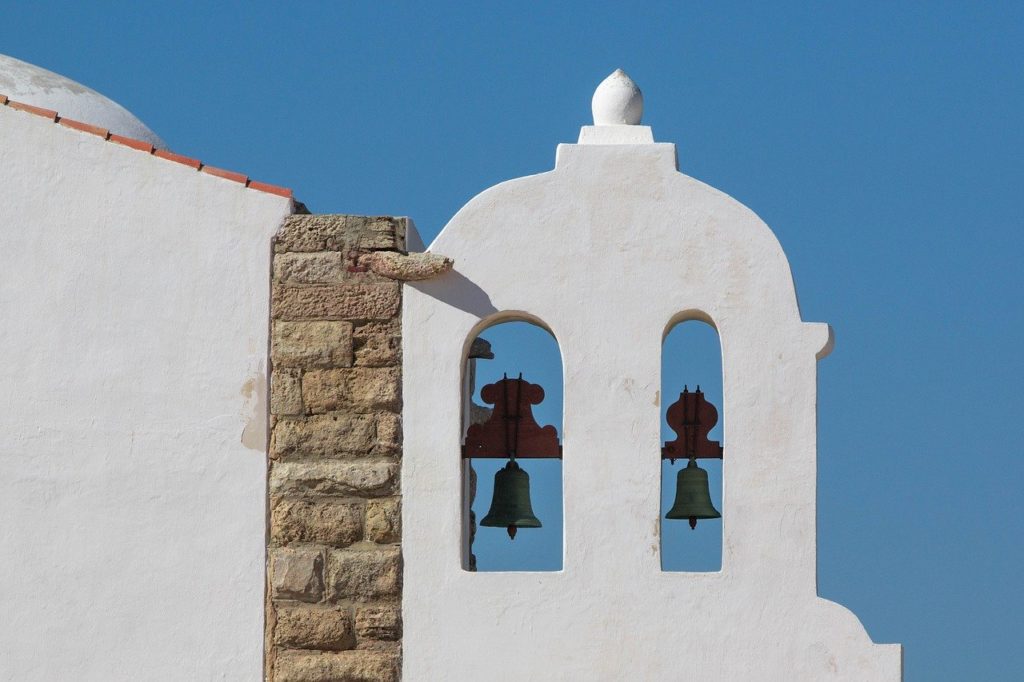 a white building with bells in the window