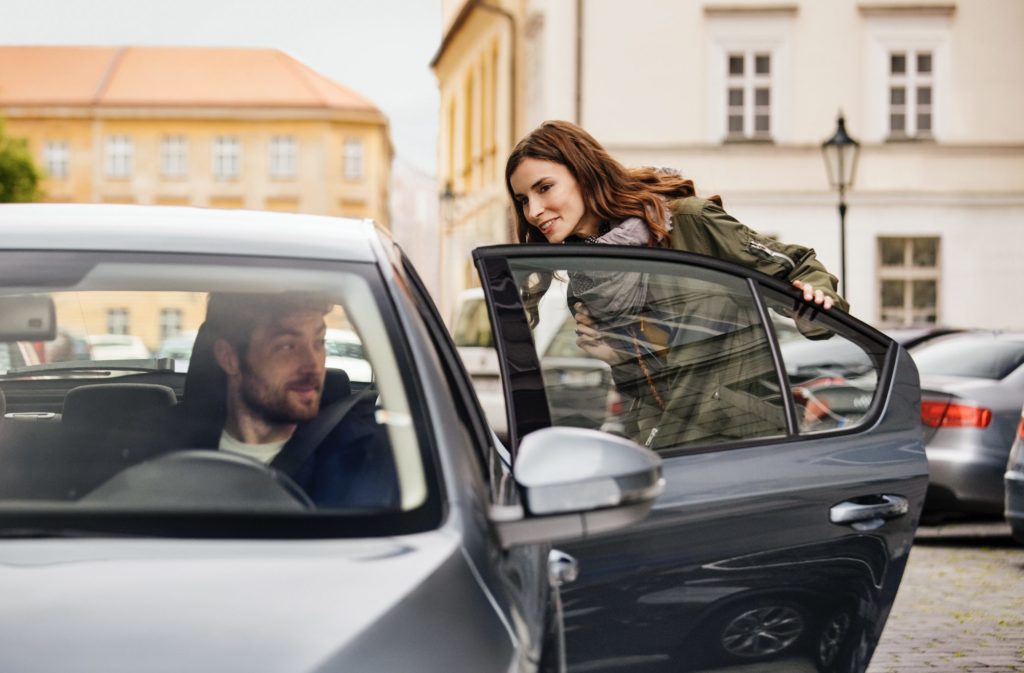 a woman leaning out of a car door