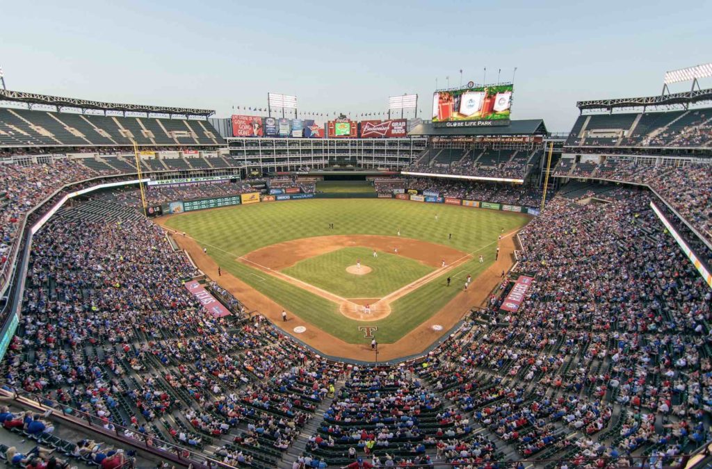 a baseball stadium with people in the stands with Globe Life Park in Arlington in the background