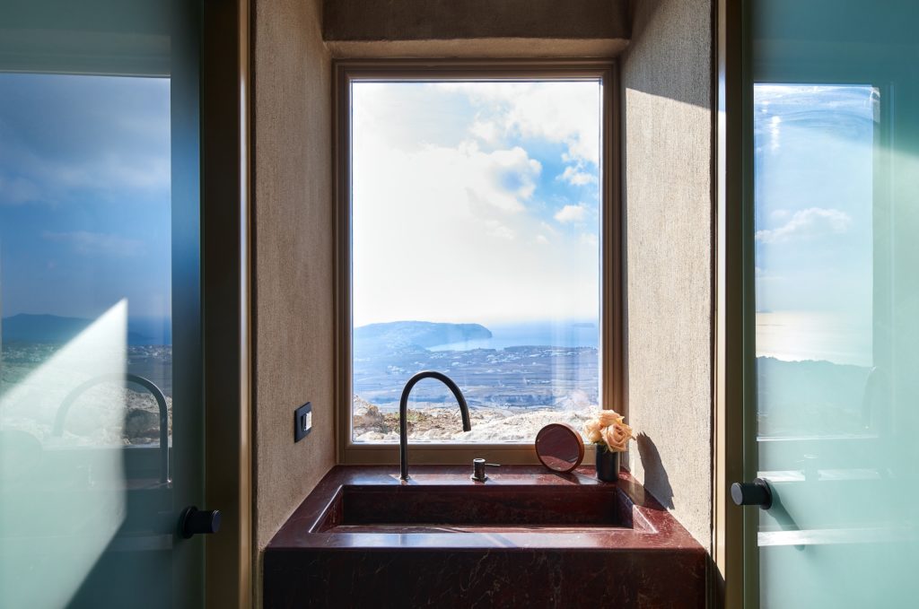 a sink in a room with a window and a view of the mountains