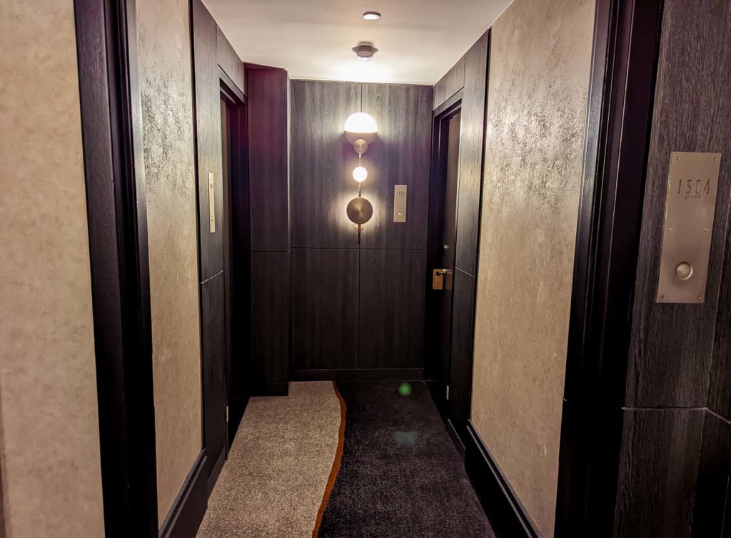 a hallway with two elevators and lights