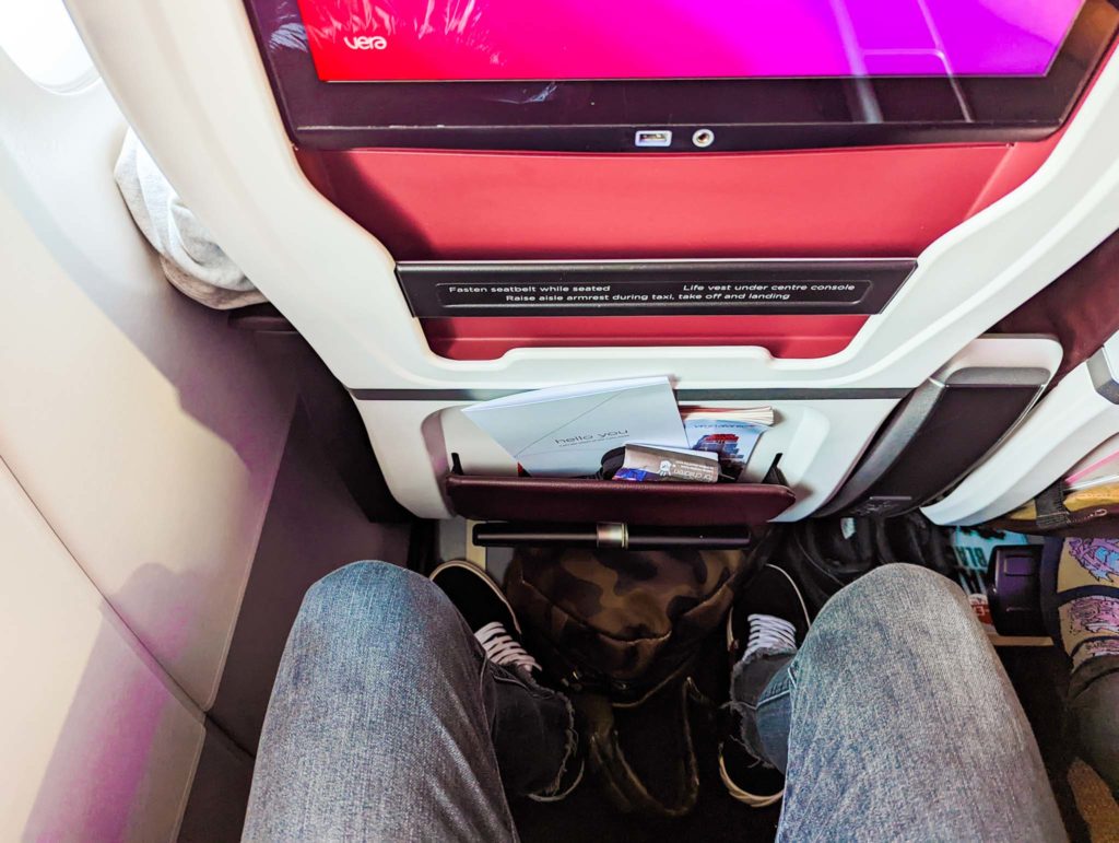 a person's legs in a seat with a tv in the back