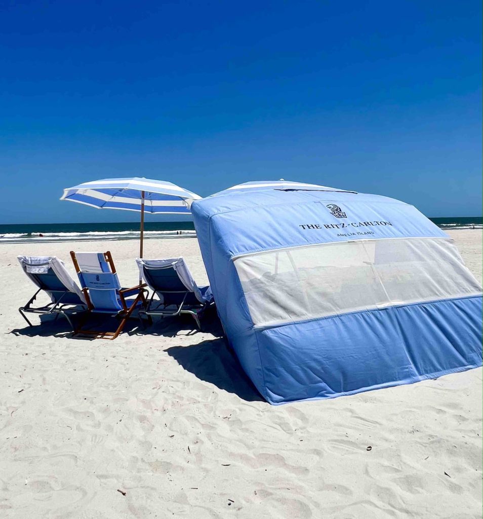 a beach tent and umbrella on a beach