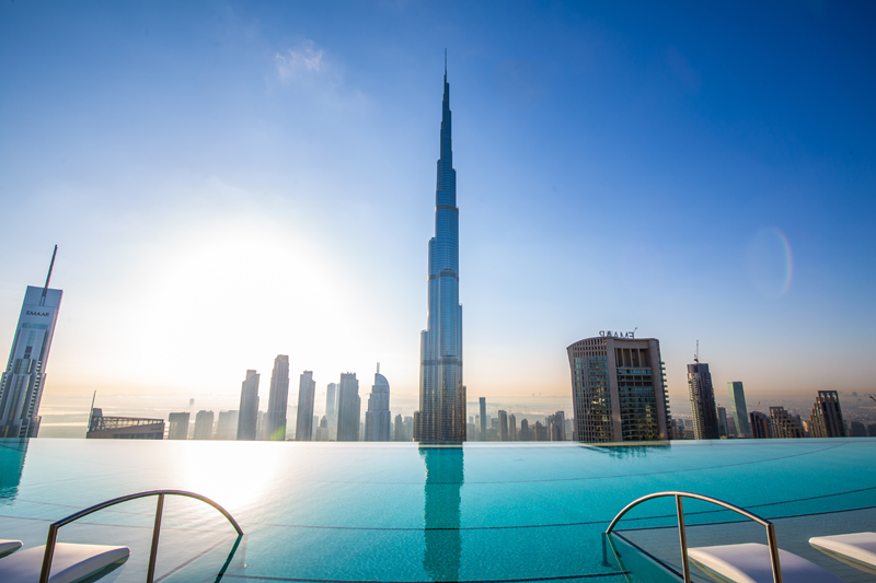 a pool with a tall building in the background with Burj Khalifa in the background