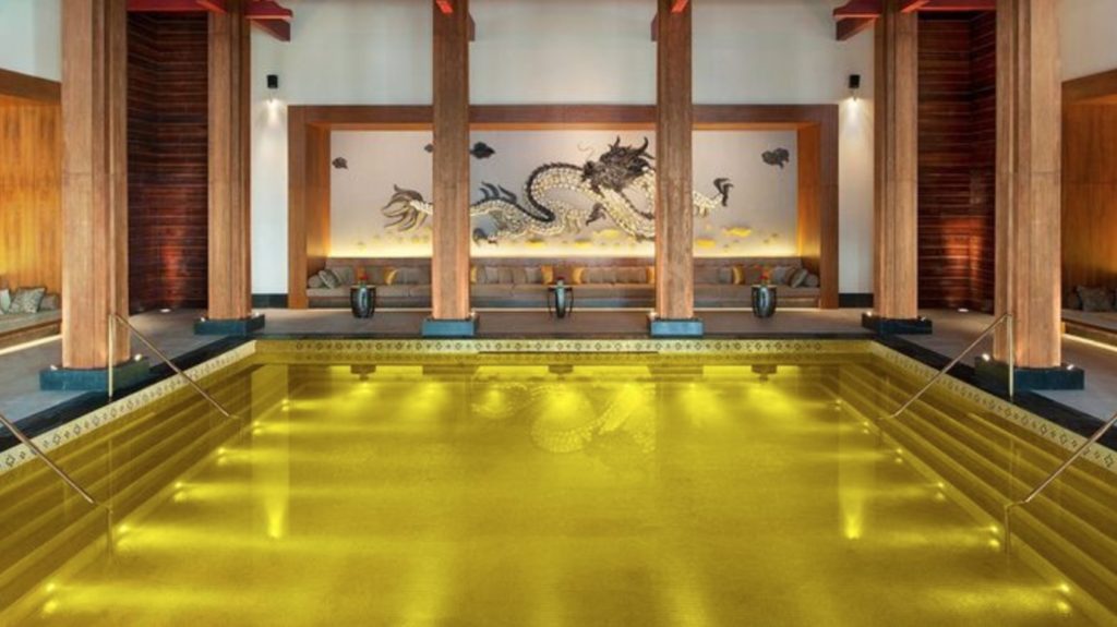 a yellow pool with a dragon on the wall