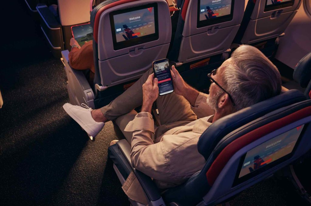 a man sitting in an airplane with a phone