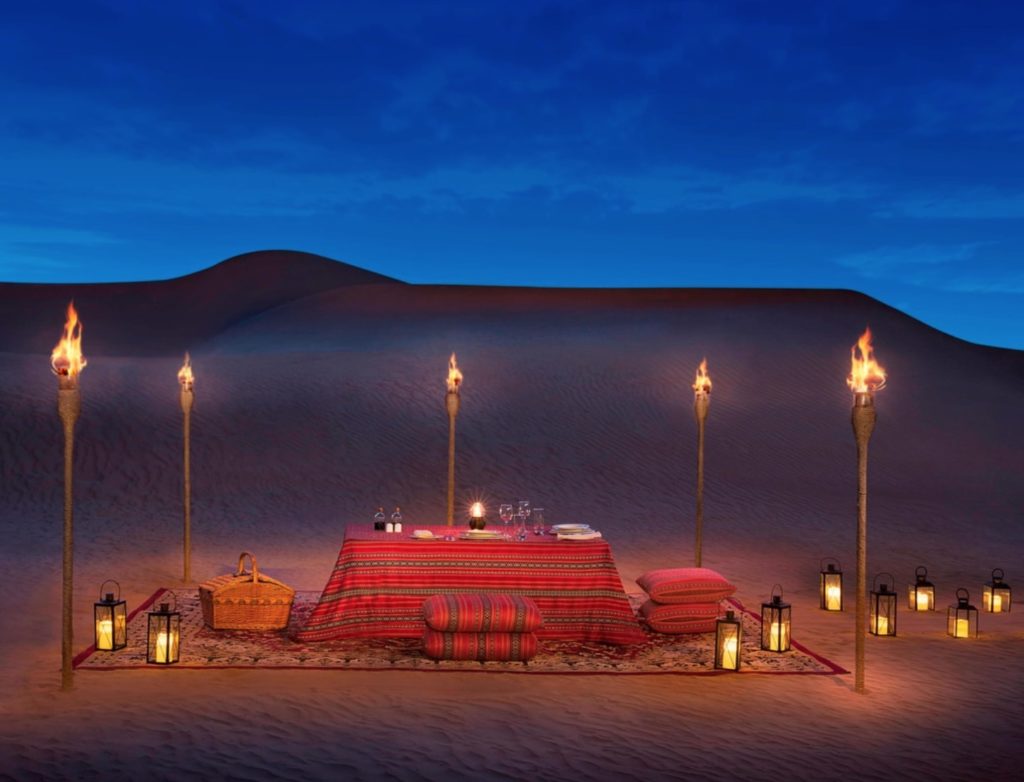 a table with a blanket and candles in the desert