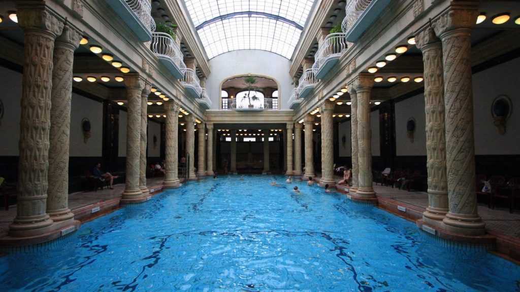 a large indoor pool with columns and a roof