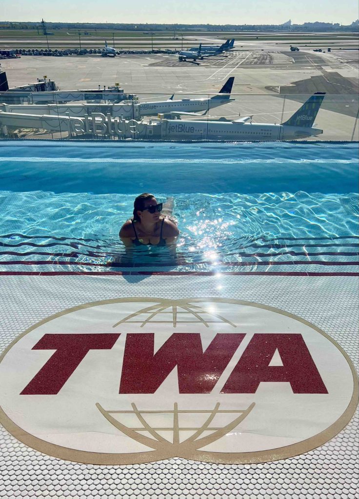 a woman in a pool with airplanes in the background