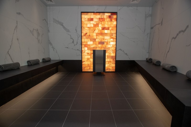 a room with a lighted wall and black tile floor